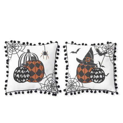 Two square white decorative throw pillows with black pom-pom trim, featuring Halloween-themed illustrations of patterned pumpkins, spiderwebs, a spider, bats, and a witch hat on a white background.