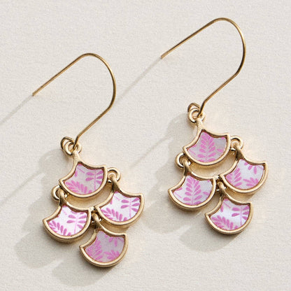Pair of gold earrings with pink leaf patterns on a light background