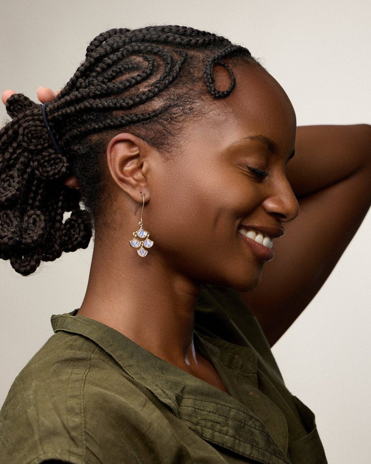 Woman with braided hair smiling against a neutral background