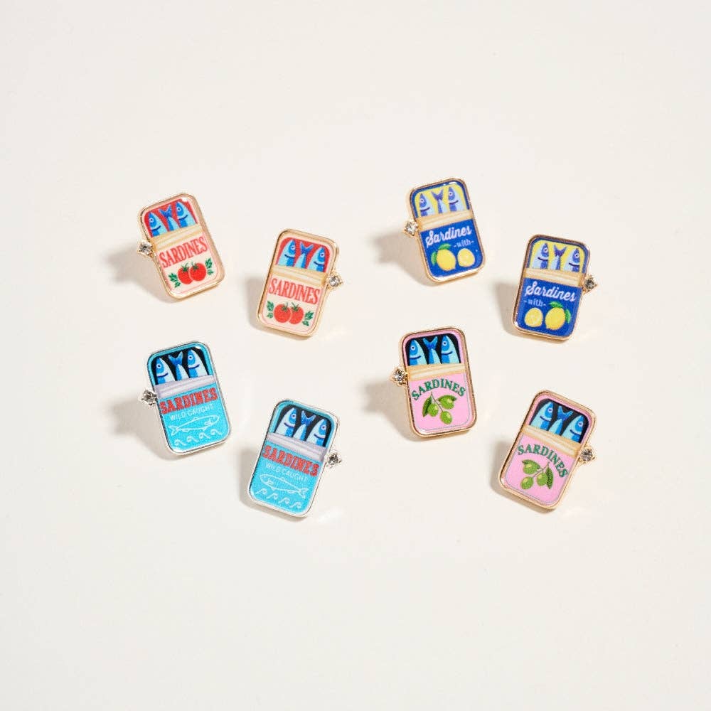 Set of colorful enamel pins shaped like canned food packages on a white background