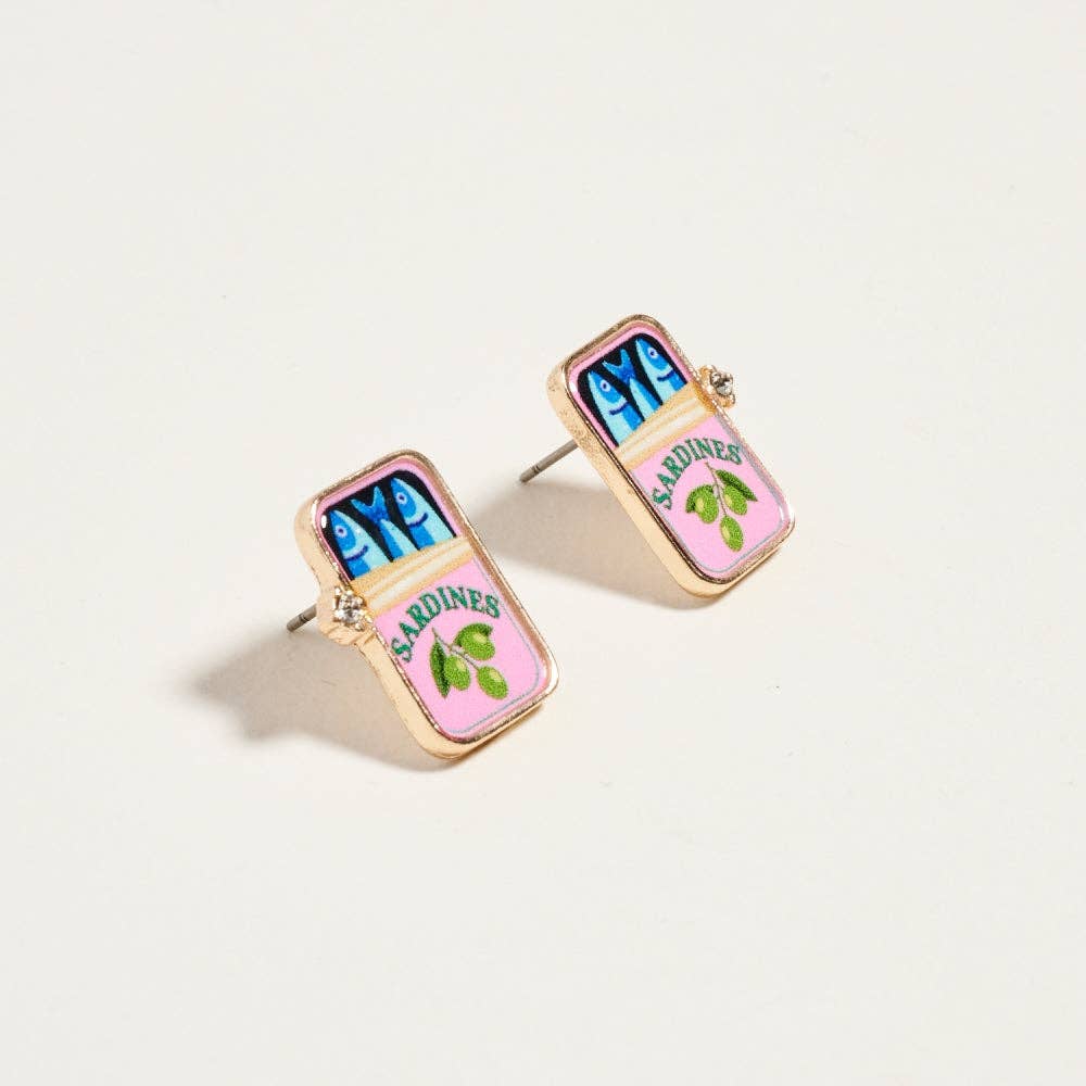 Earrings resembling sardine can packaging on a light beige background