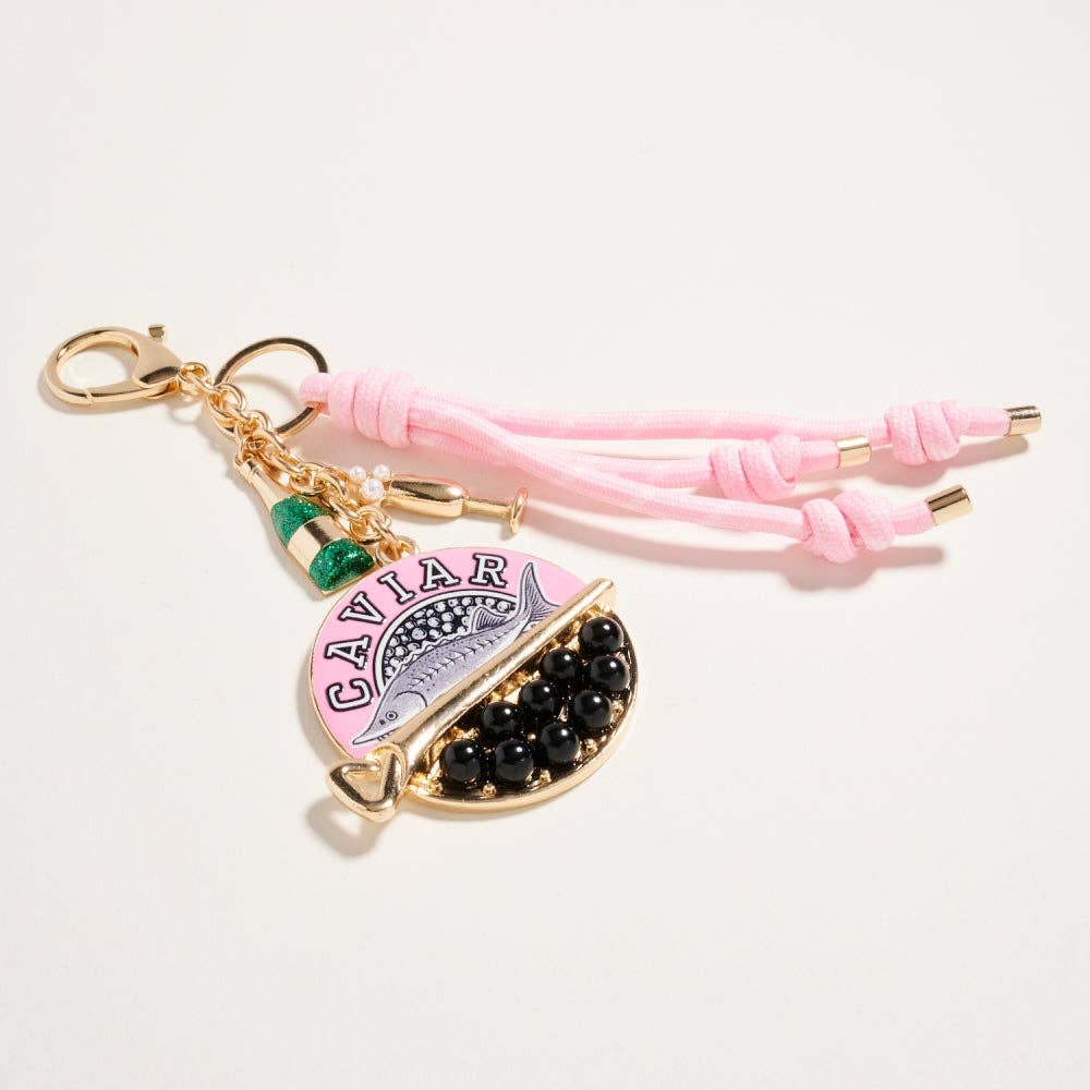 Pink keychain with 'Caviar' text and black stones on a white background