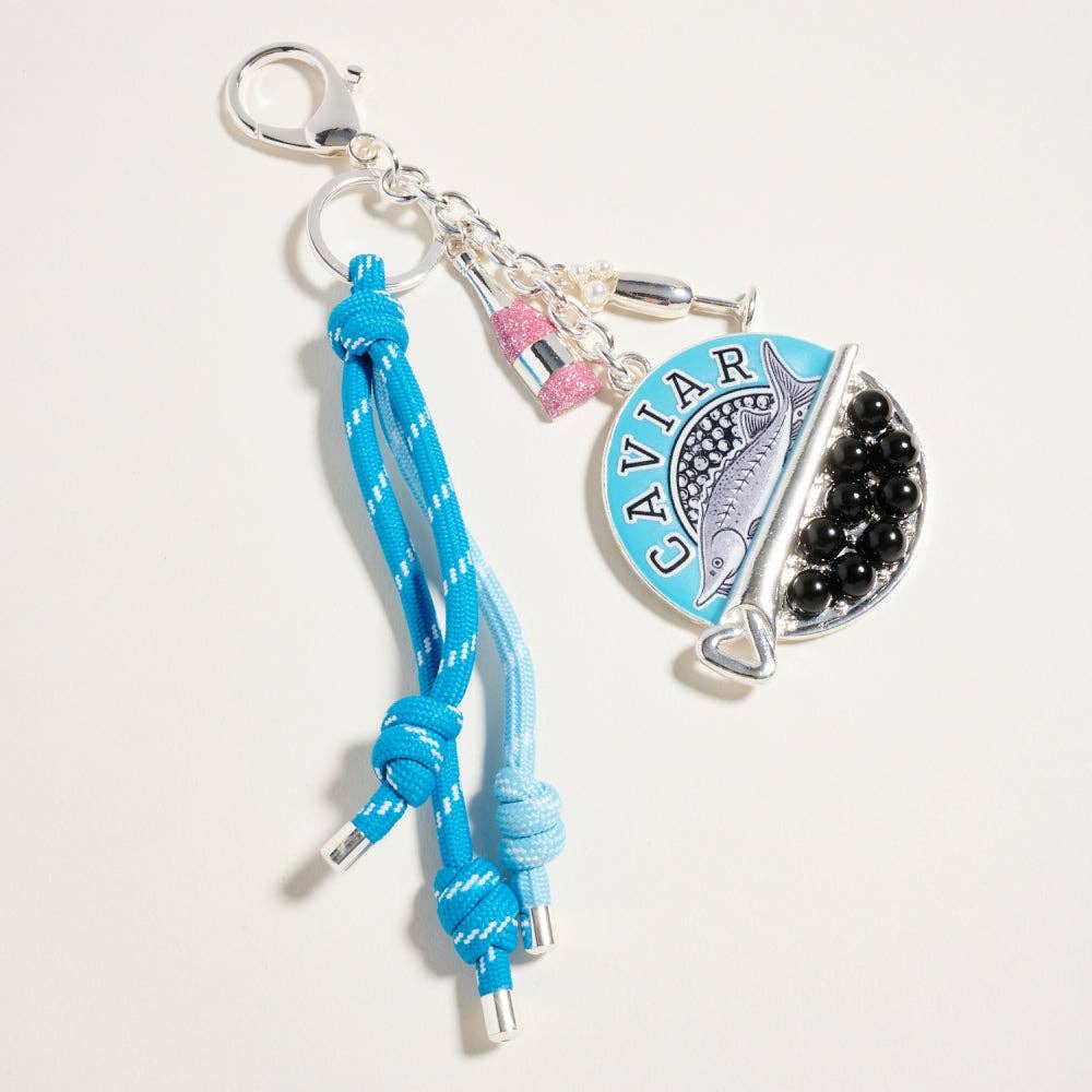 Keychain with blue rope, silver clasp, and 'Caviar' charm on a light gray background