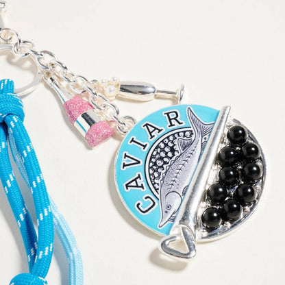 Keychain with 'Caviar' theme featuring a blue pendant, black beads, and a blue lanyard on a white background.