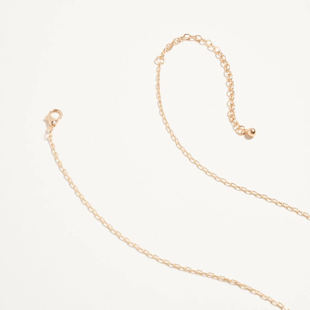 Gold chain necklace on a light beige background