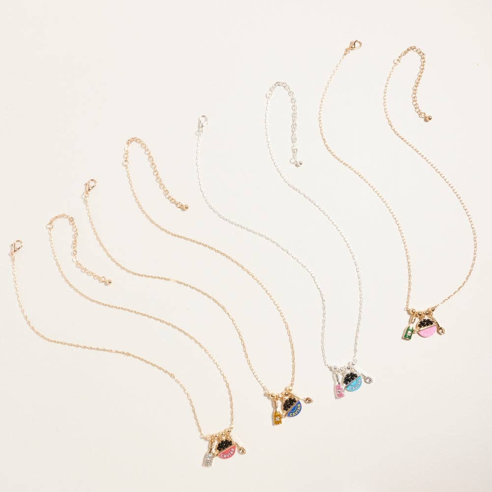Gold plated caviar and champagne charm necklace with pink glitter accents and miniature spoon pendant on white background