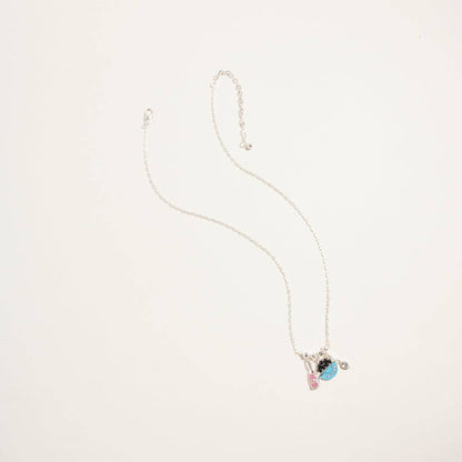 Silver chain necklace with turquoise blue caviar tin and champagne bottle charms for coastal luxe vacation style