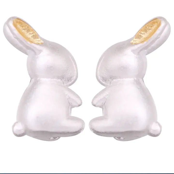 Pair of white rabbit-shaped earrings on a white background
