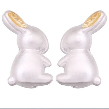 Pair of white rabbit-shaped earrings on a white background