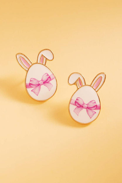 Easter-themed earrings with bunny ears and pink bows on a yellow background