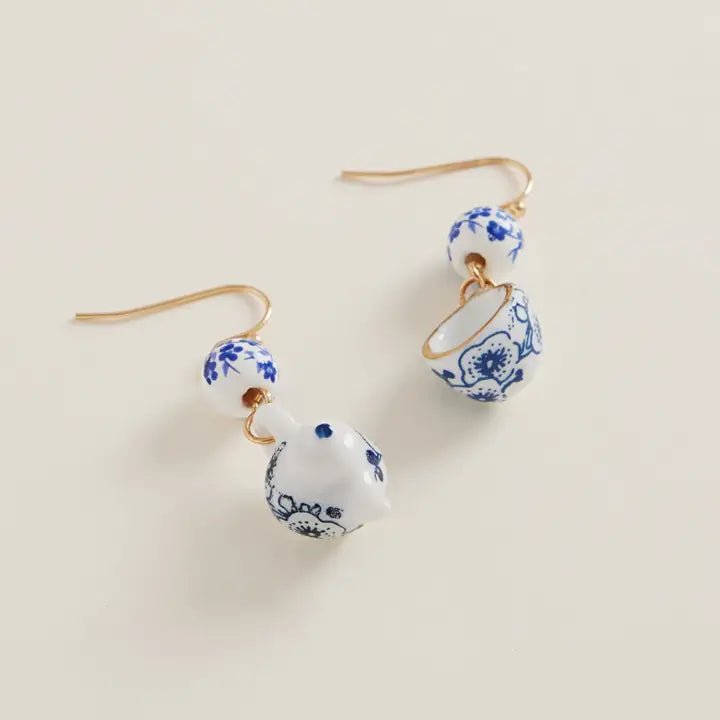 Pair of earrings with blue floral patterns on a beige background