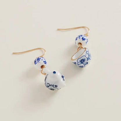 Pair of earrings with blue floral patterns on a beige background