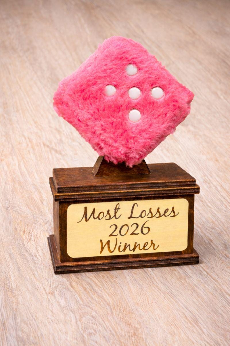Trophy with pink fuzzy die and wooden base on a light wood background