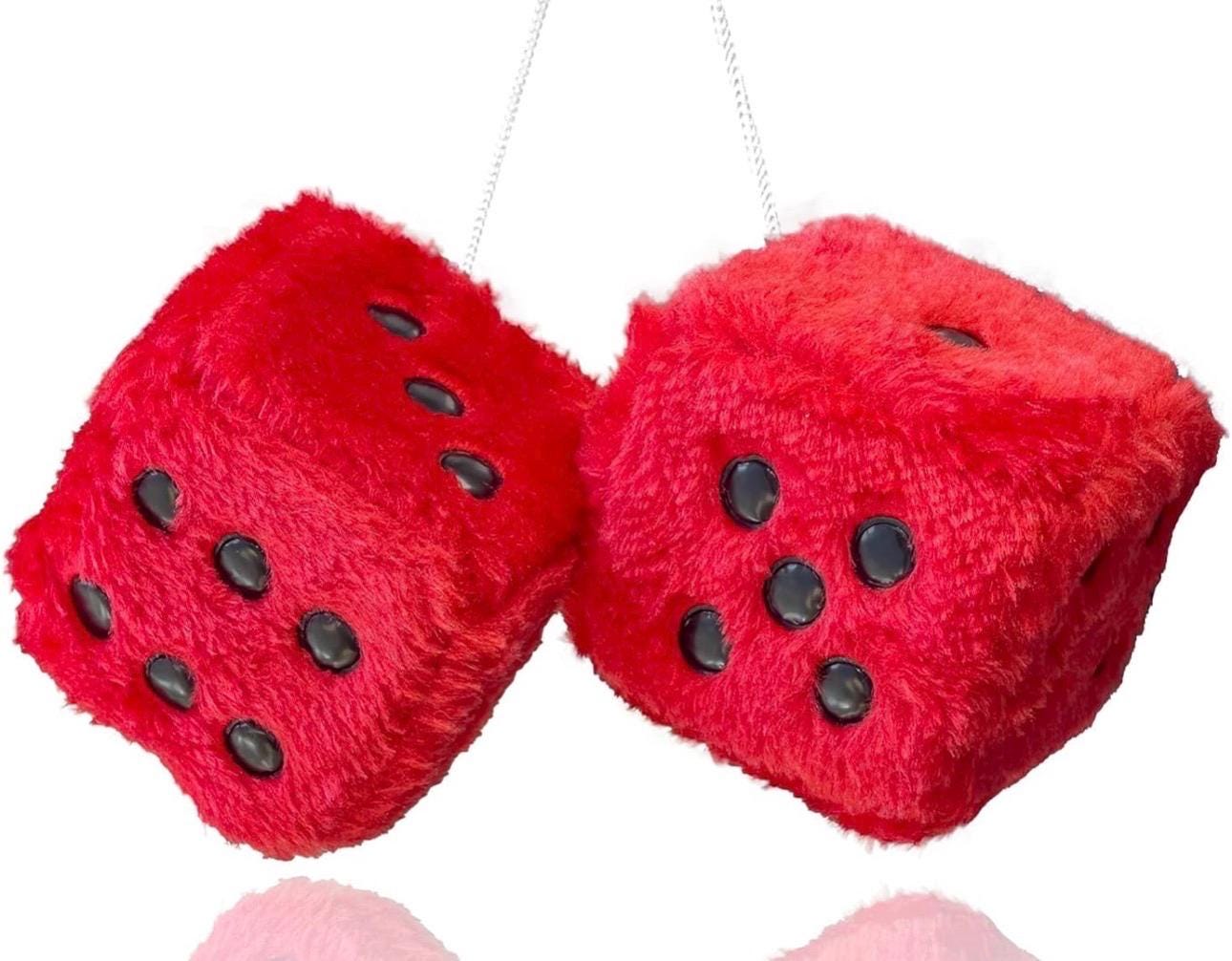 Red fuzzy dice with black dots on a white background