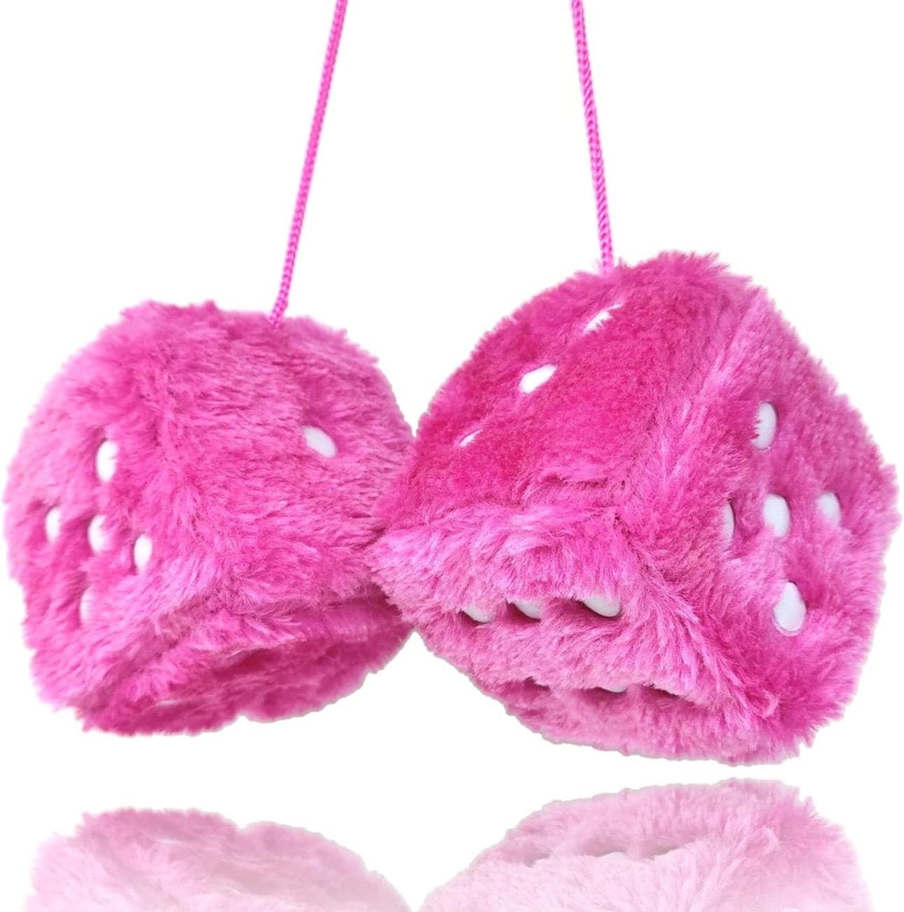Pink fuzzy dice with white dots on a white background
