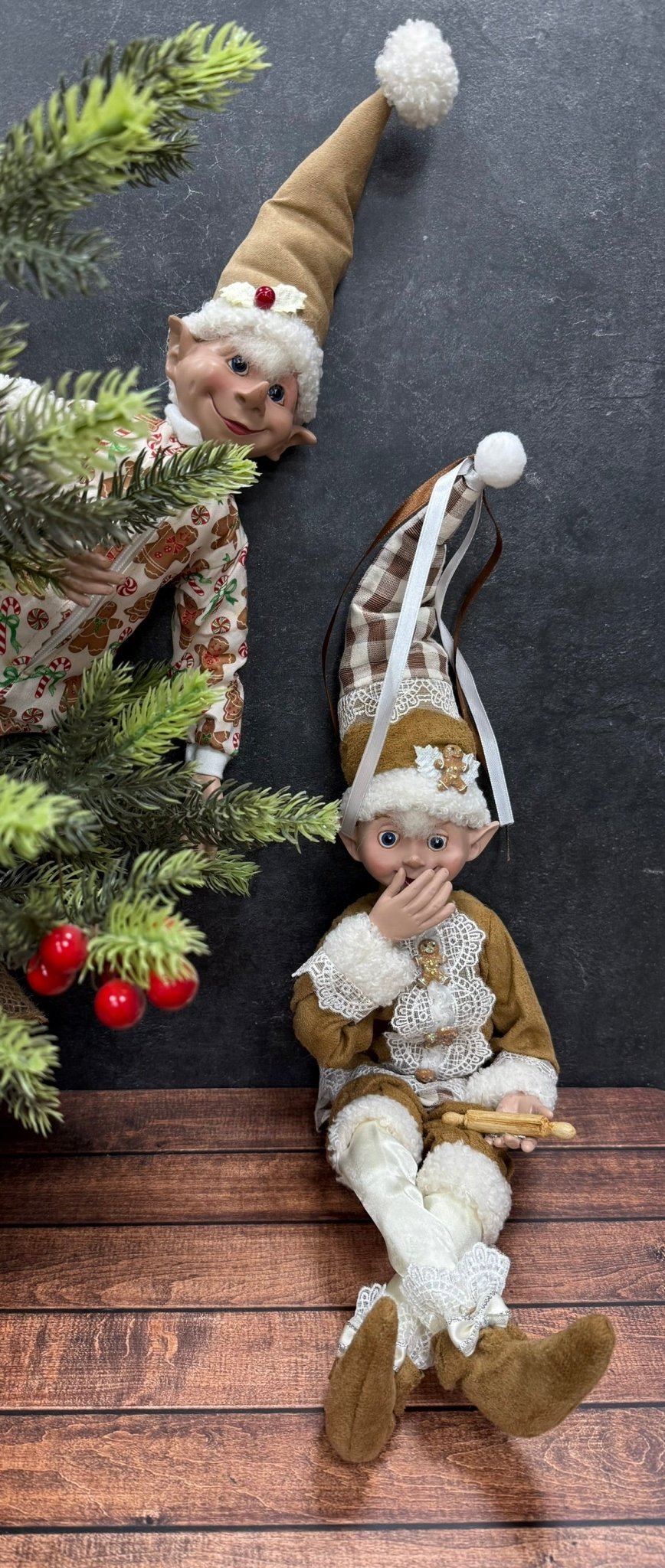 Two elf figurines on a wooden surface with a dark background