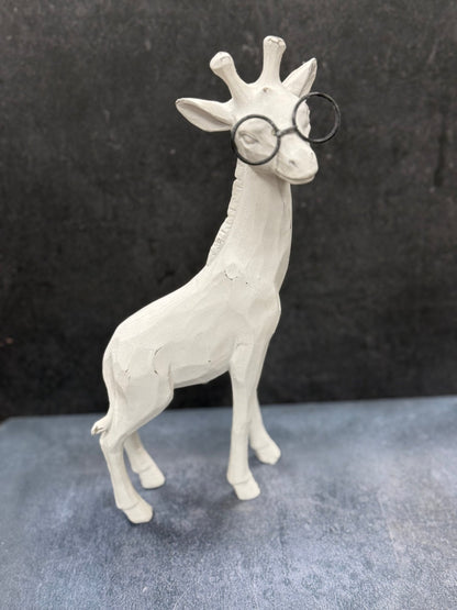 White giraffe figurine wearing glasses on a dark background