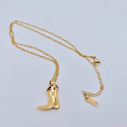 Gold necklace with a boot-shaped pendant on a light gray background