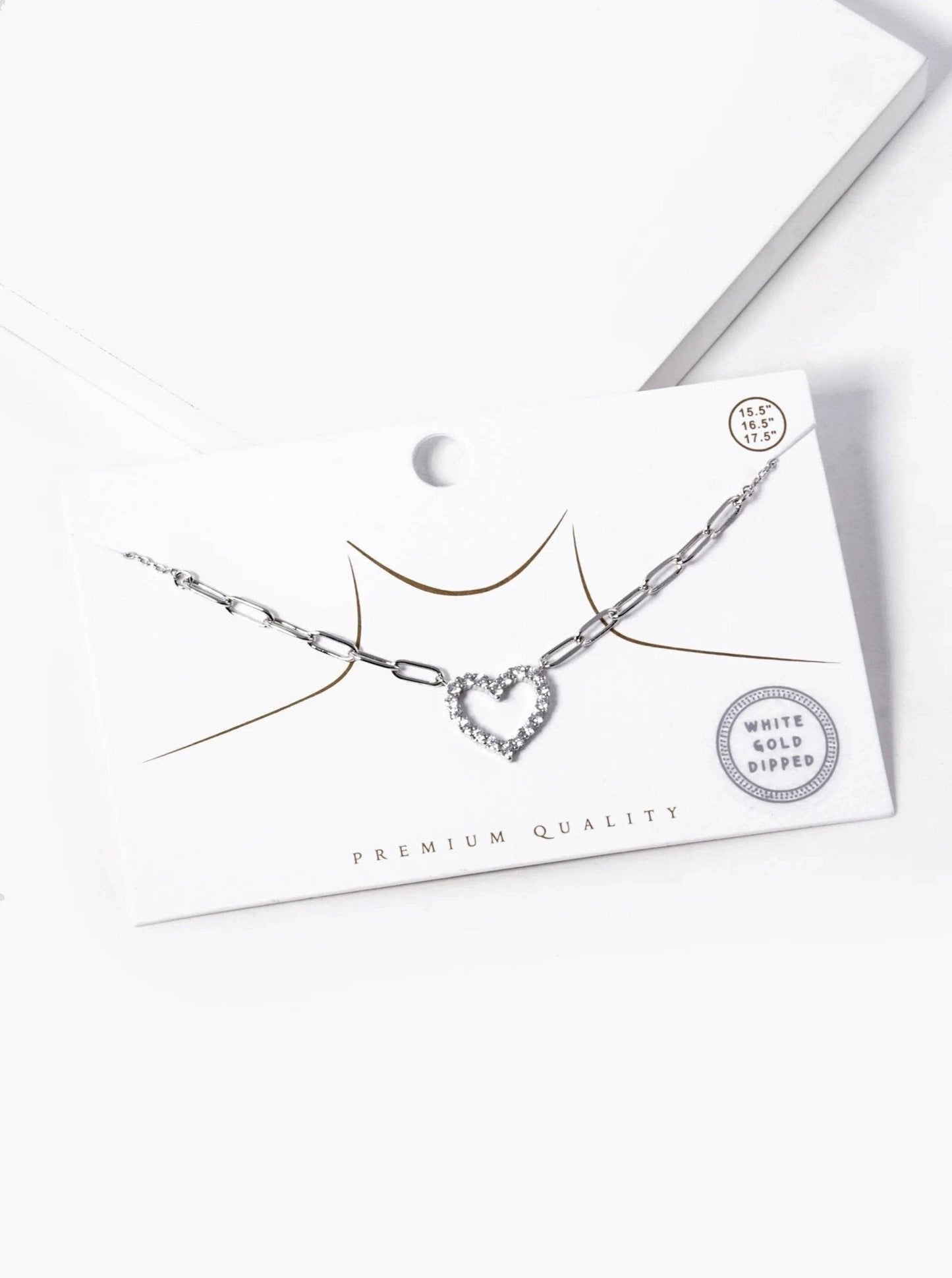 Necklace with heart-shaped pendant on a white card with 'Premium Quality' text