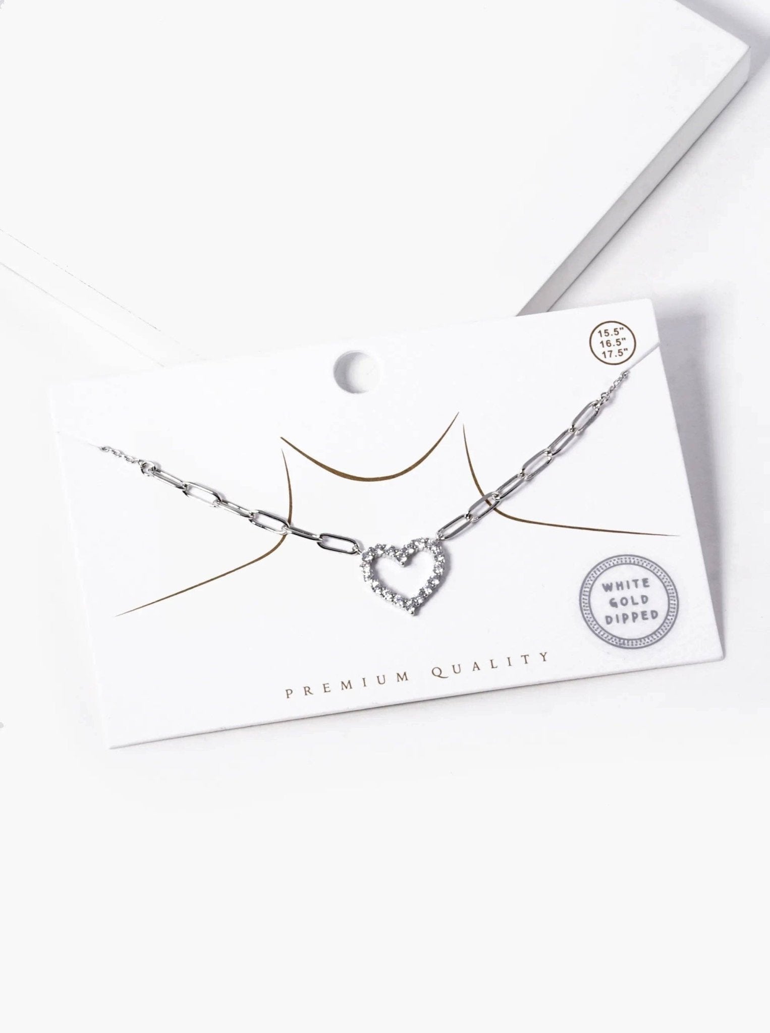 Necklace with heart-shaped pendant on a white card with 'Premium Quality' text